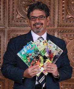 Dr. Naif Al-Mutawa photographed with some copies of The 99, the first group of comic superheroes born of an Islamic archetype, which he created. 
