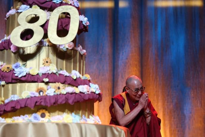 His Holiness the 14th Dalai Lama posing with his birthday cake from the Art Institute of Orange County