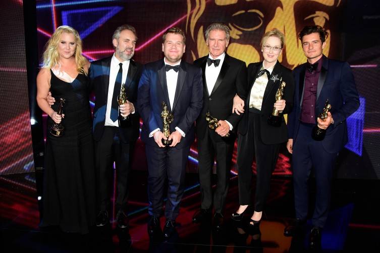 Honorees (L-R) Amy Schumer (holding the Charlie Chaplin Britannia Award for Excellence in Comedy presented by Kodak), Sam Mendes (holding the John Schlesinger Britannia Award for Excellence in Directing presented by The GREAT Britain Campaign), James Corden (holding the Britannia Award for British Artist of the Year presented by Burberry), Harrison Ford (holding the Albert R. Broccoli Britannia Award for Worldwide Contribution to Entertainment), Meryl Streep (holding the Stanley Kubrick Britannia Award for Excellence in Film) and Orlando Bloom (holding the Britannia Humanitarian Award presented by The Beazley Group) pose onstage during the 2015 Jaguar Land Rover British Academy Britannia Awards 