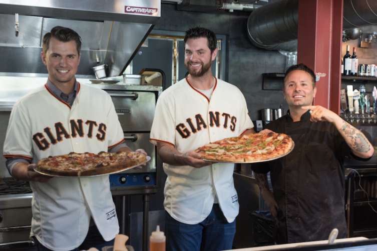 Joe Panik and Brandon Belt show off the pizzas they made with Tony Gemingani.