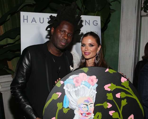 NEW YORK, NY - SEPTEMBER 27: Artist Bradley Theodore (L) presents an artwork to Georgina Chapman at the Haute Living Celebrates Georgina Chapman with Perrier-Jouet and JetSmarter event at Socialista New York on September 27, 2016 in New York City. (Photo by Rob Kim/Getty Images for Haute Living)