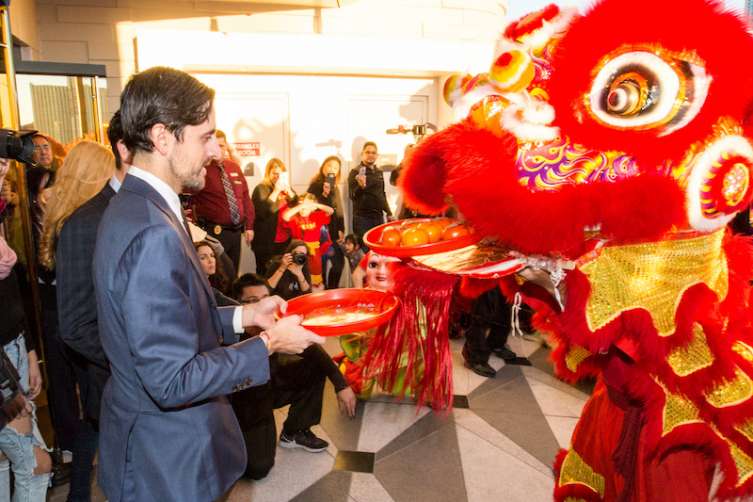 Lucky Dragon  COO Dave Jacoby offers a tray of persimmons to a lion at the Lucky Dragon grand opening.