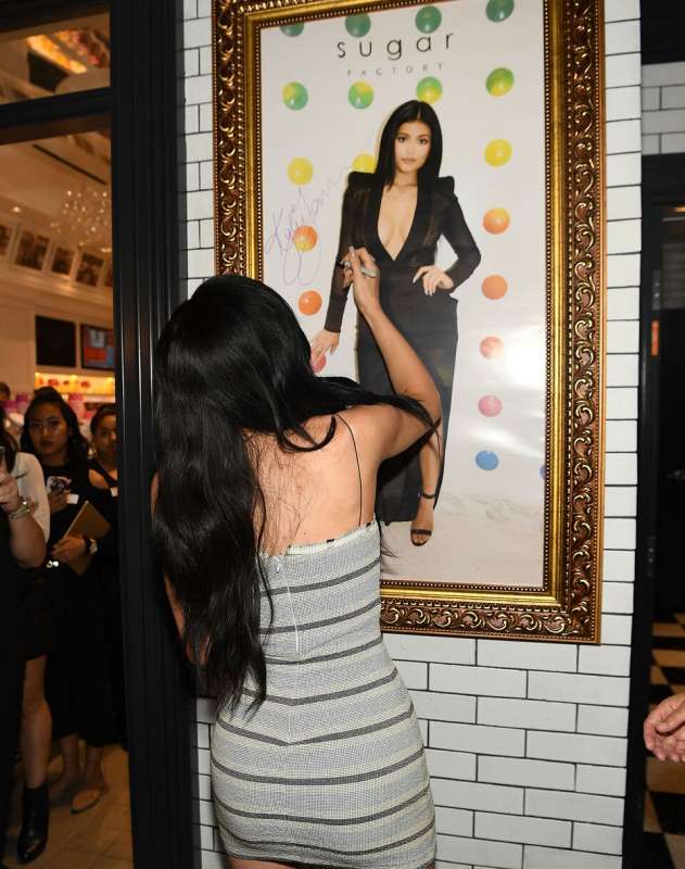Kylie Jenner signing a framed photo of herself in the Sugar Factory confectionary. 