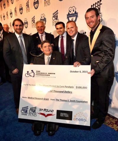 Thomas Smith, Chris Smith, and Teague Egan presenting the $100,000 donation to Marc Buoniconti at the 30th Great Sports Legends Dinner in 2015