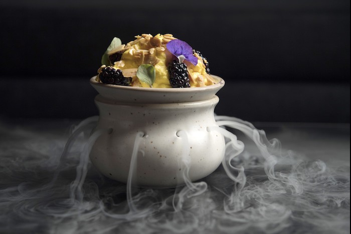 For dessert, Daulet Ki Chaat, a tres leches-inspired dessert with a baba rum base, saffron milk foam and blackberries is served in a clay vessel that releases dry ice smoke, unveiling the light and delicate treat.