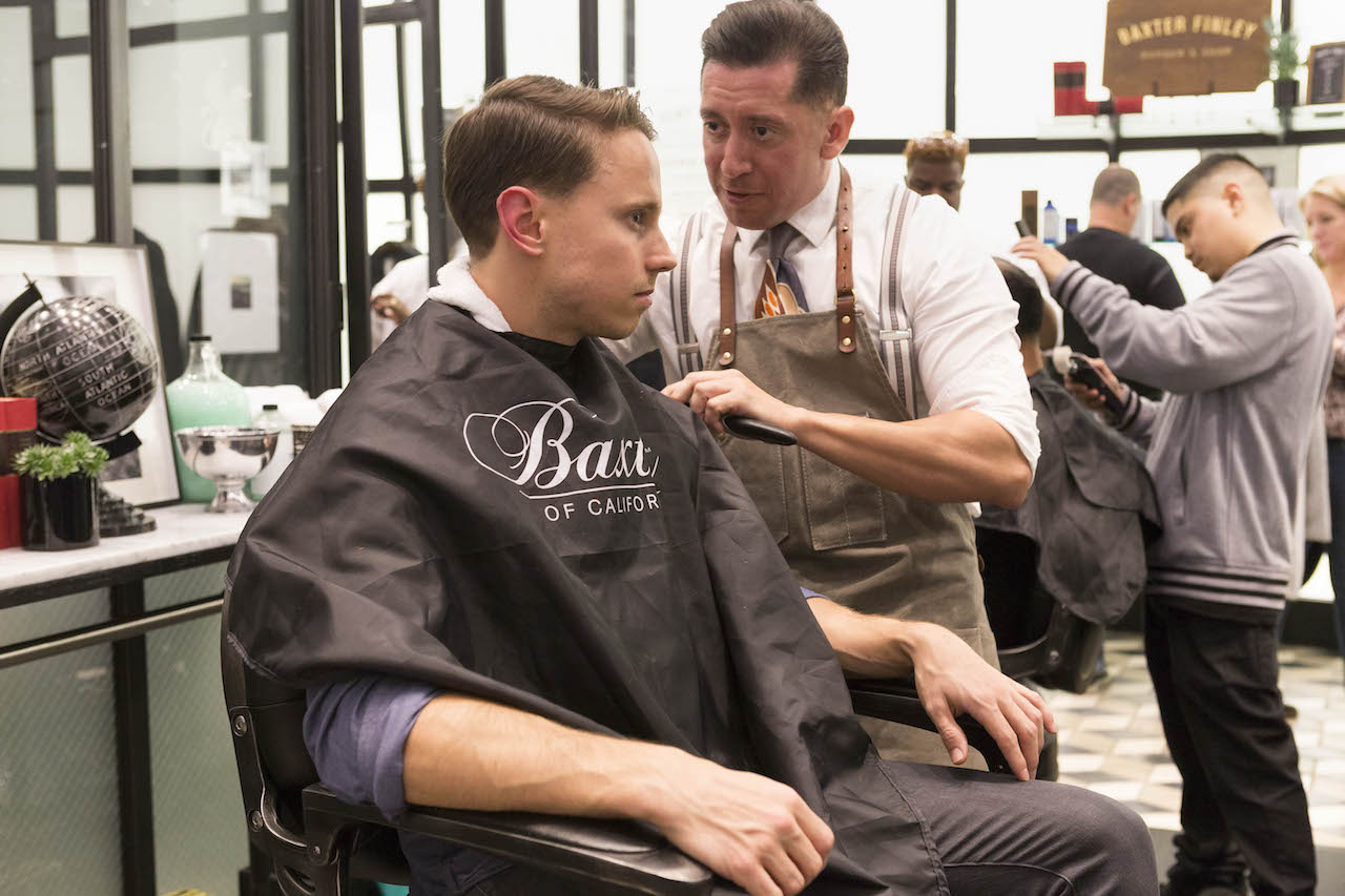 A man gets a hair trim at the Baxter of California pop up at Banana Republic