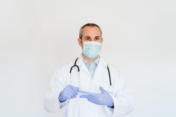 Portrait,Of,Caucasian,Doctor,Using,Protective,Gloves,And,Mask.,Working