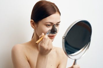 Woman,Puts,On,Her,Nose,A,Clay,Mask,Looks,In