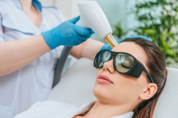 Relaxed,Woman,In,Protective,Goggles,Receiving,Laser,Treatment,In,Clinic