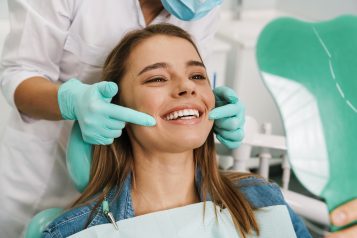 European,Young,Woman,Smiling,While,Looking,At,Mirror,In,Dental