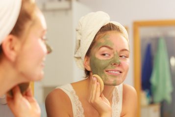 Woman,Removing,Facial,Dried,Clay,Mud,Mask,With,Sponge,In