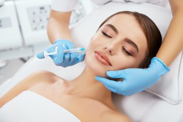 Beauty,Salon,,Doctor’s,Hands,In,Blue,Gloves,Holding,Syrringe,With
