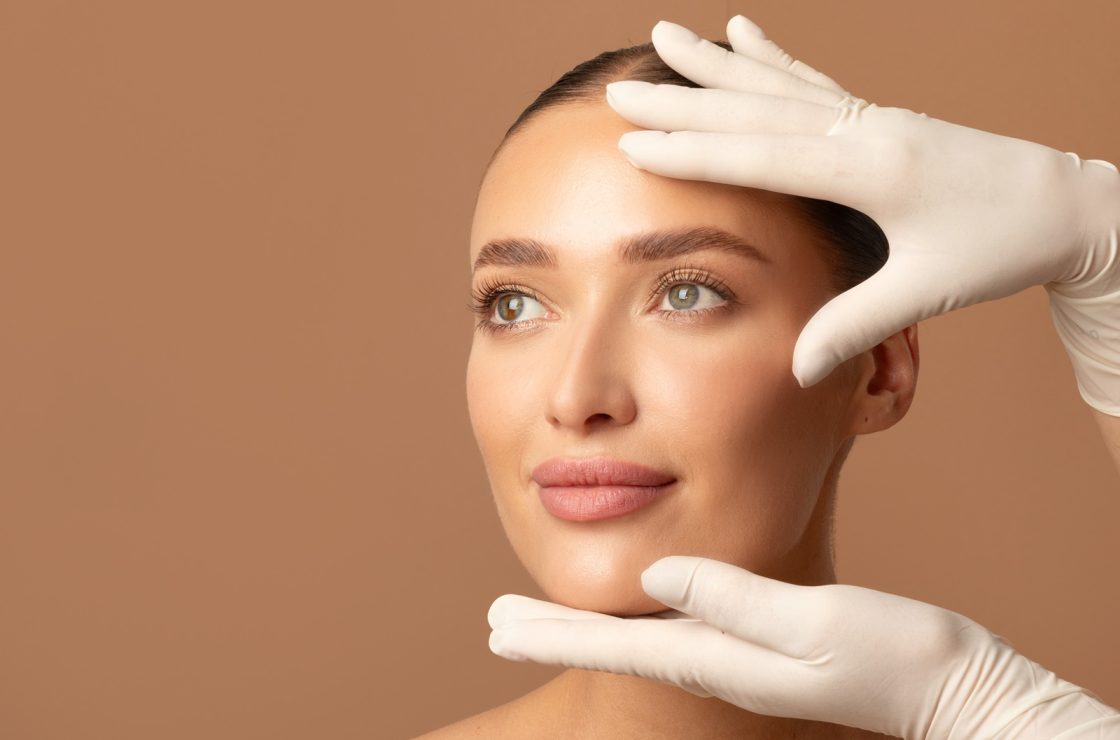 Doctor examining young woman's face, beautiful lady during visit to cosmetologist cabinet - cosmetics surgery trends 2026