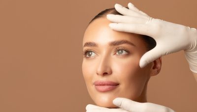 Doctor examining young woman's face, beautiful lady during visit to cosmetologist cabinet - cosmetics surgery trends 2026
