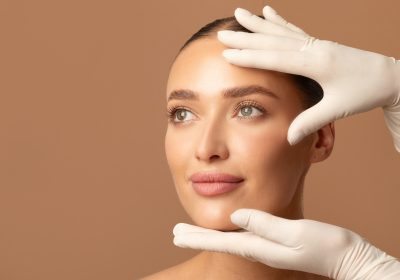 Doctor examining young woman's face, beautiful lady during visit to cosmetologist cabinet - cosmetics surgery trends 2026