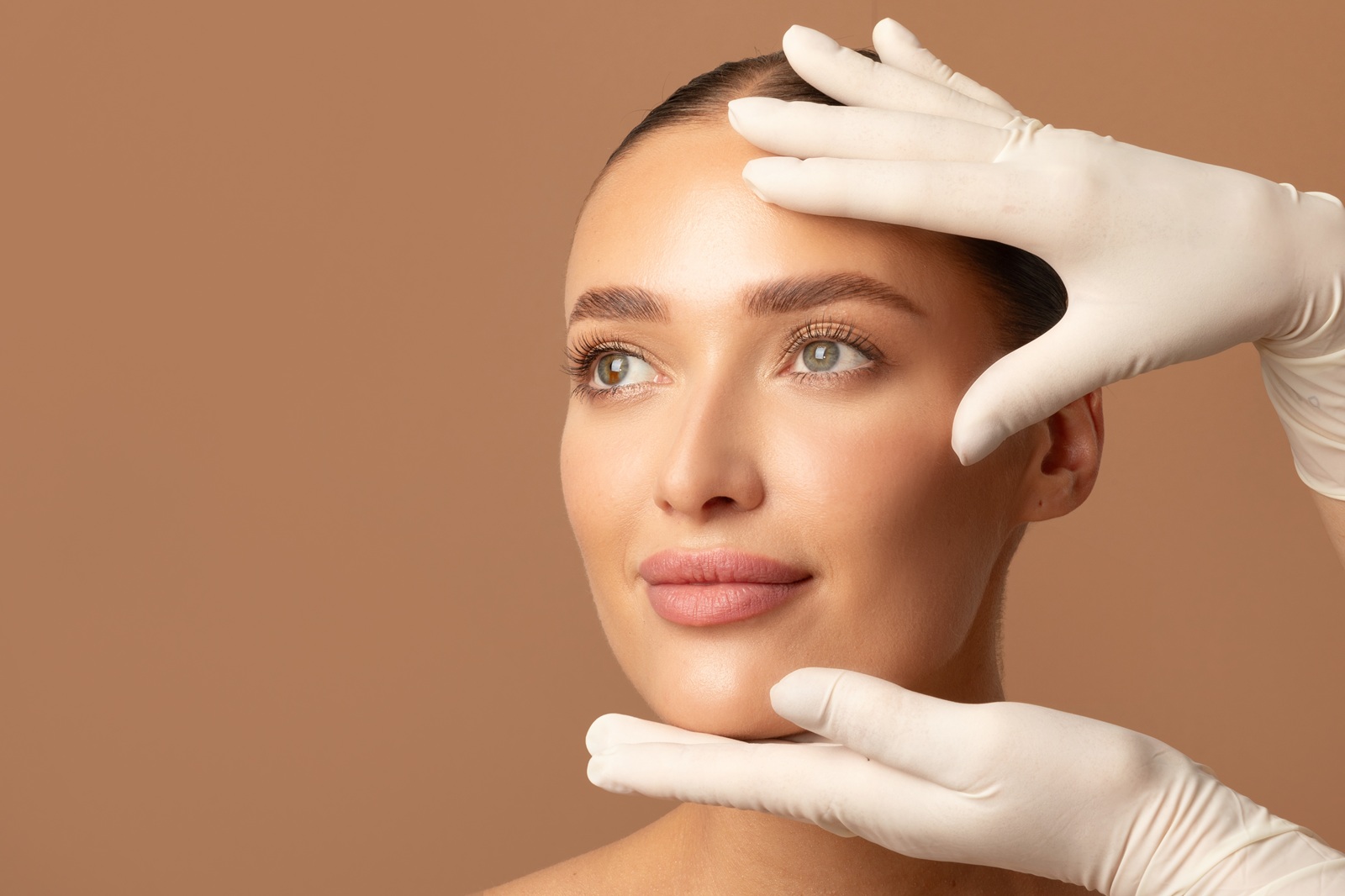 Doctor examining young woman's face, beautiful lady during visit to cosmetologist cabinet - cosmetics surgery trends 2026