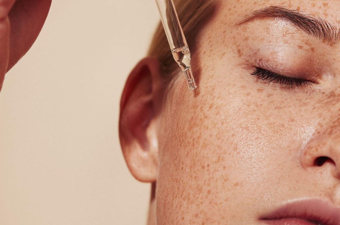 beauty model applying serum to the face