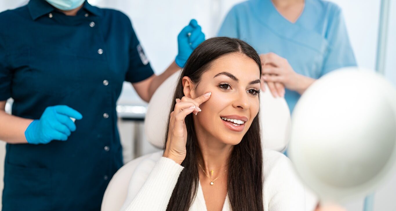 beautiful and happy young woman sitting in medical chair and looking in the mirror
