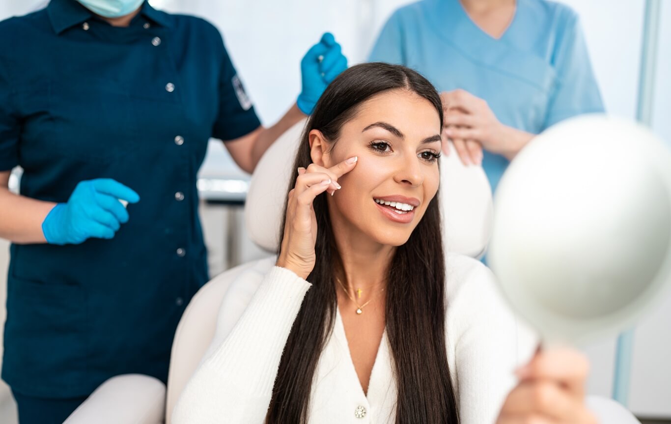 beautiful and happy young woman sitting in medical chair and looking in the mirror