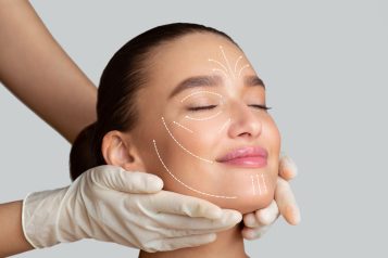 calm girl receiving face massage from cosmetologist who wearing protective gloves, isolated