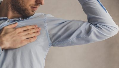 men checking his underarms for sweating