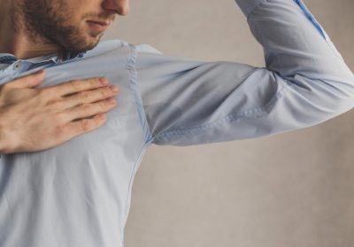 men checking his underarms for sweating