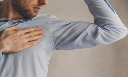 men checking his underarms for sweating