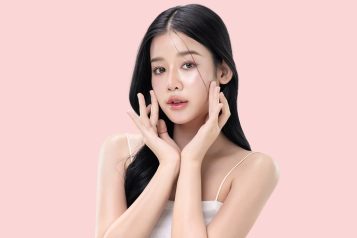 glowing skin make up style of beautiful young Asian model isolated on pink background