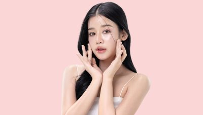 glowing skin make up style of beautiful young Asian model isolated on pink background