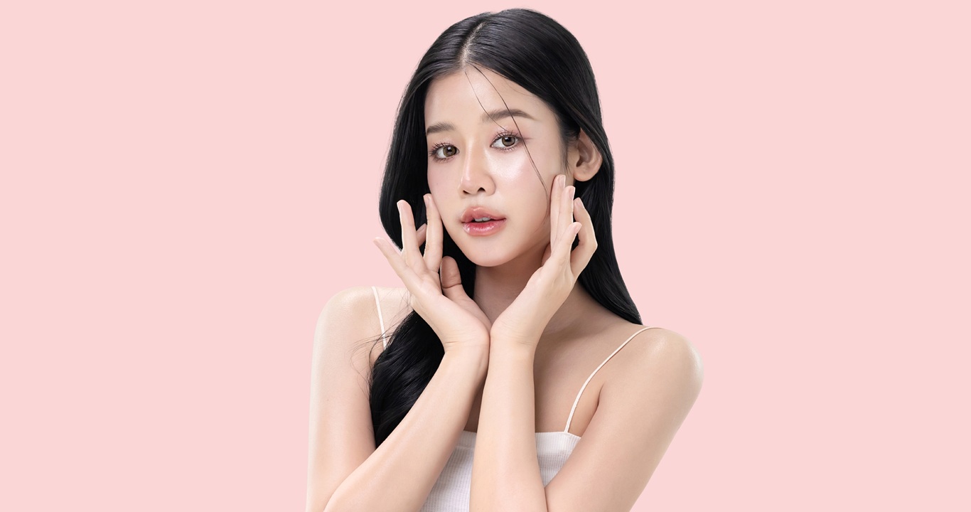glowing skin make up style of beautiful young Asian model isolated on pink background