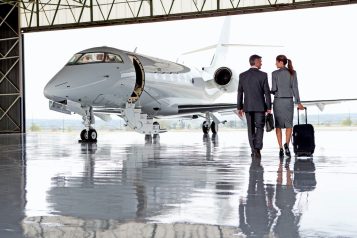 Businesswoman,And,Businessman,Walking,Towards,A,Private,Jet