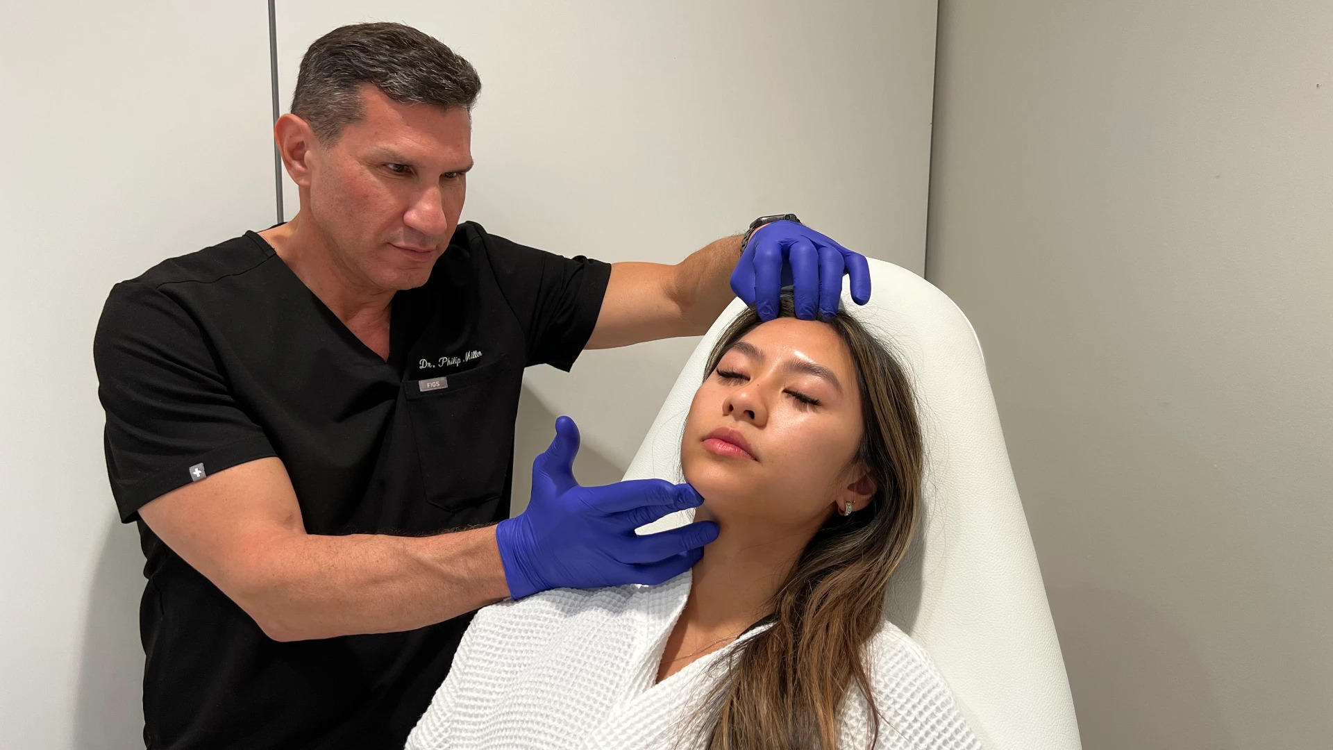 Dr. Philip J. Miller performing a facial rejuvenation treatment on a patient