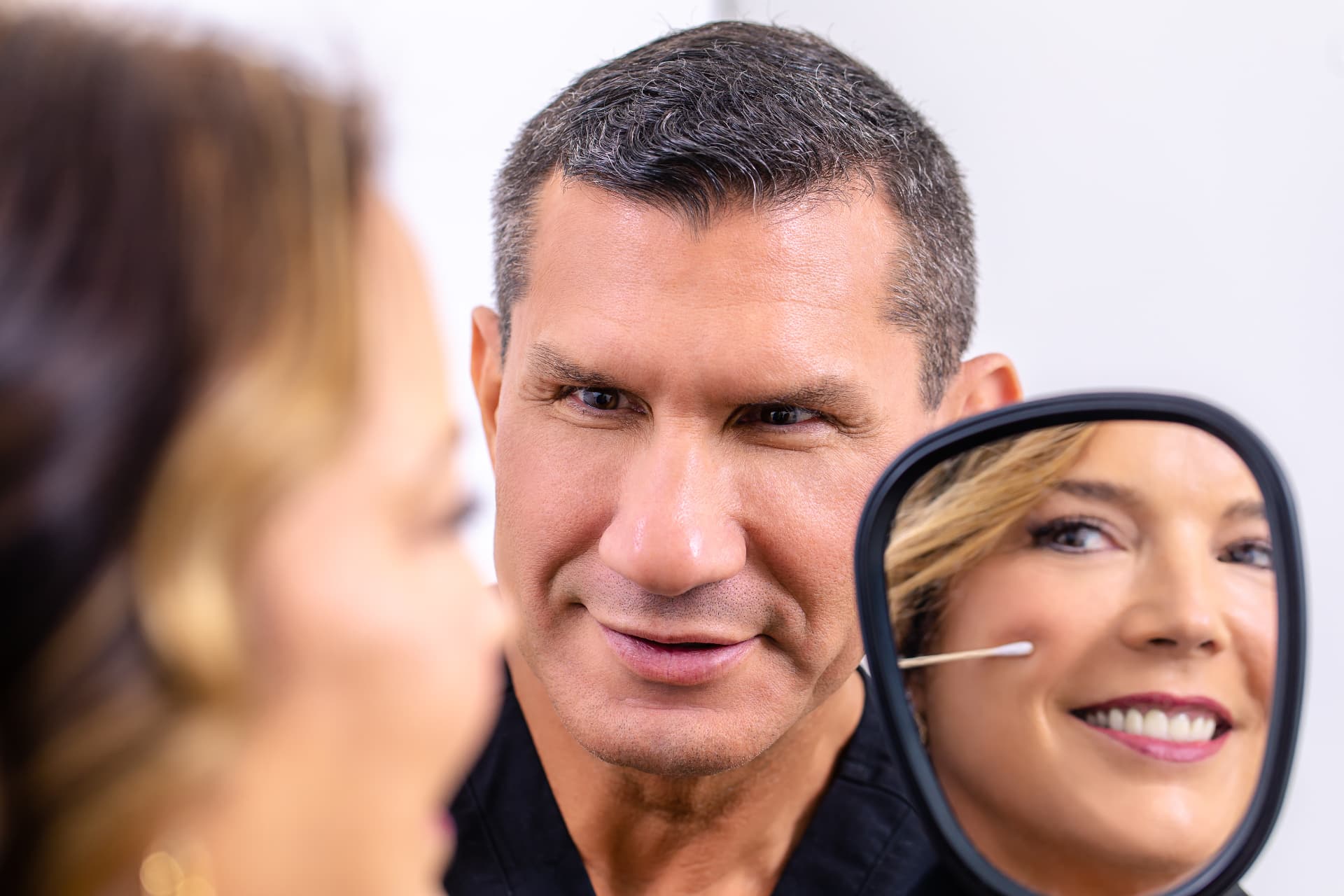 Dr. Philip J. Miller reviewing facial rejuvenation results with a patient using a handheld mirror