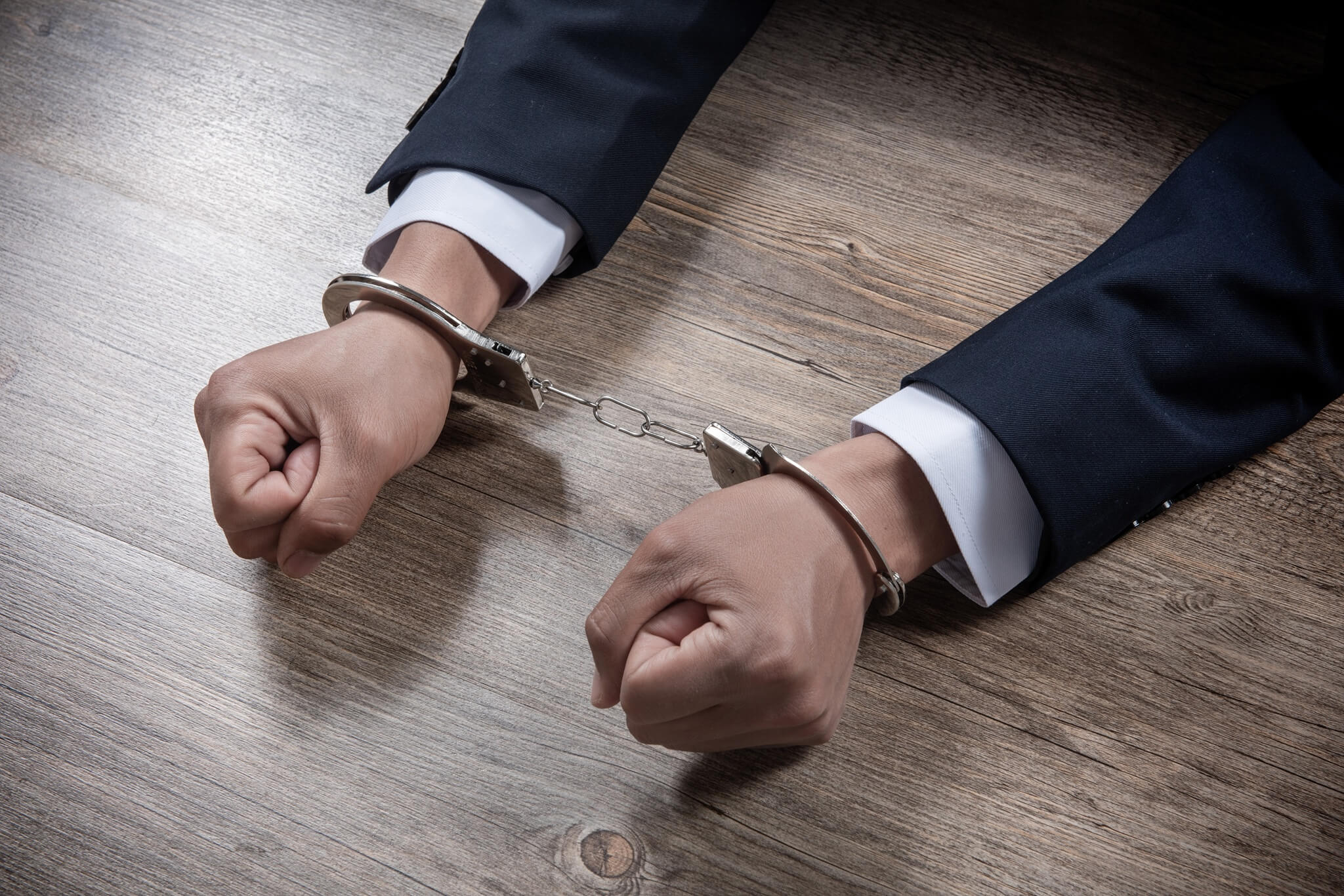 handcuffed hands of a prisoner on table