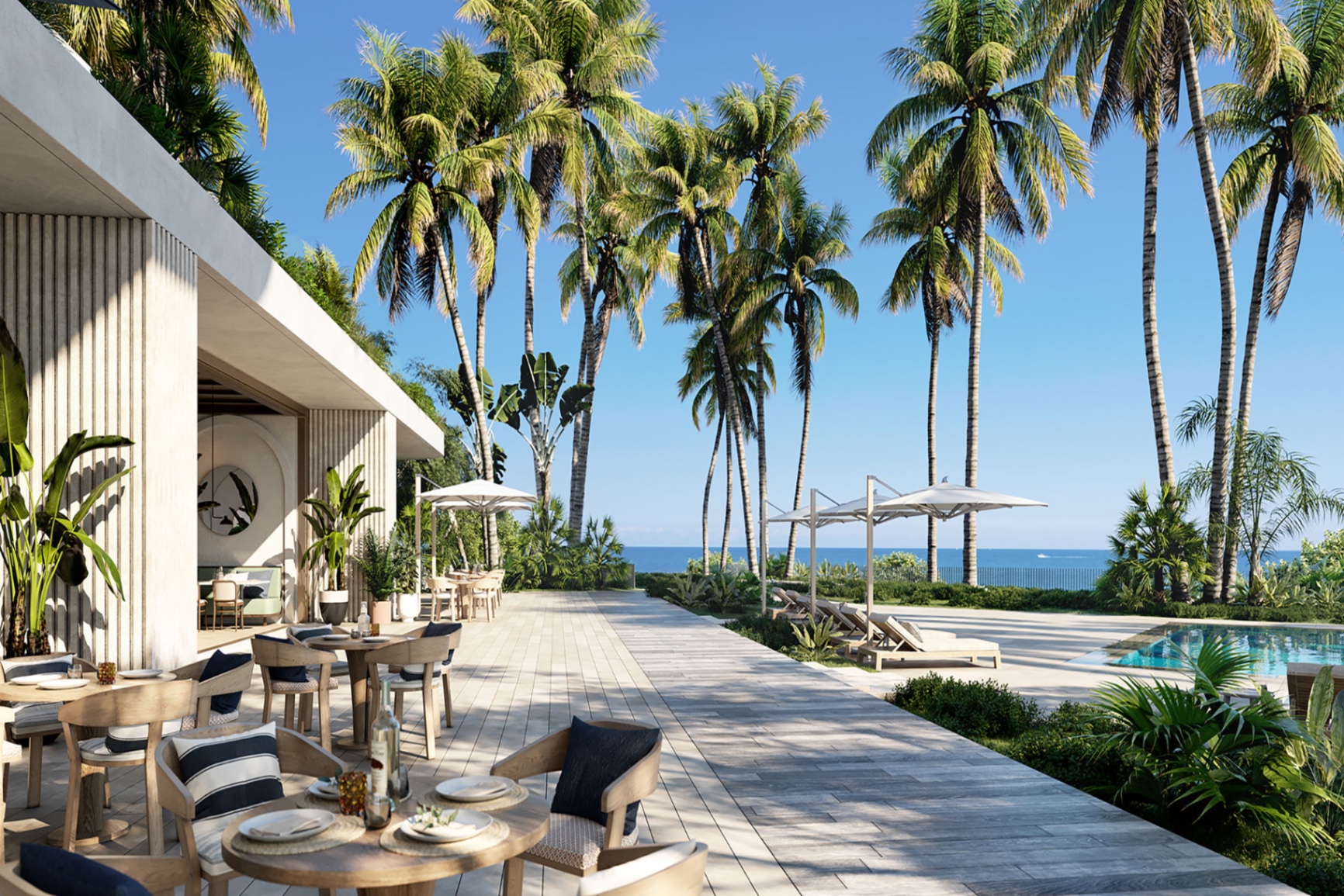 Resort-style branded residence pool deck framed by palms with ocean view