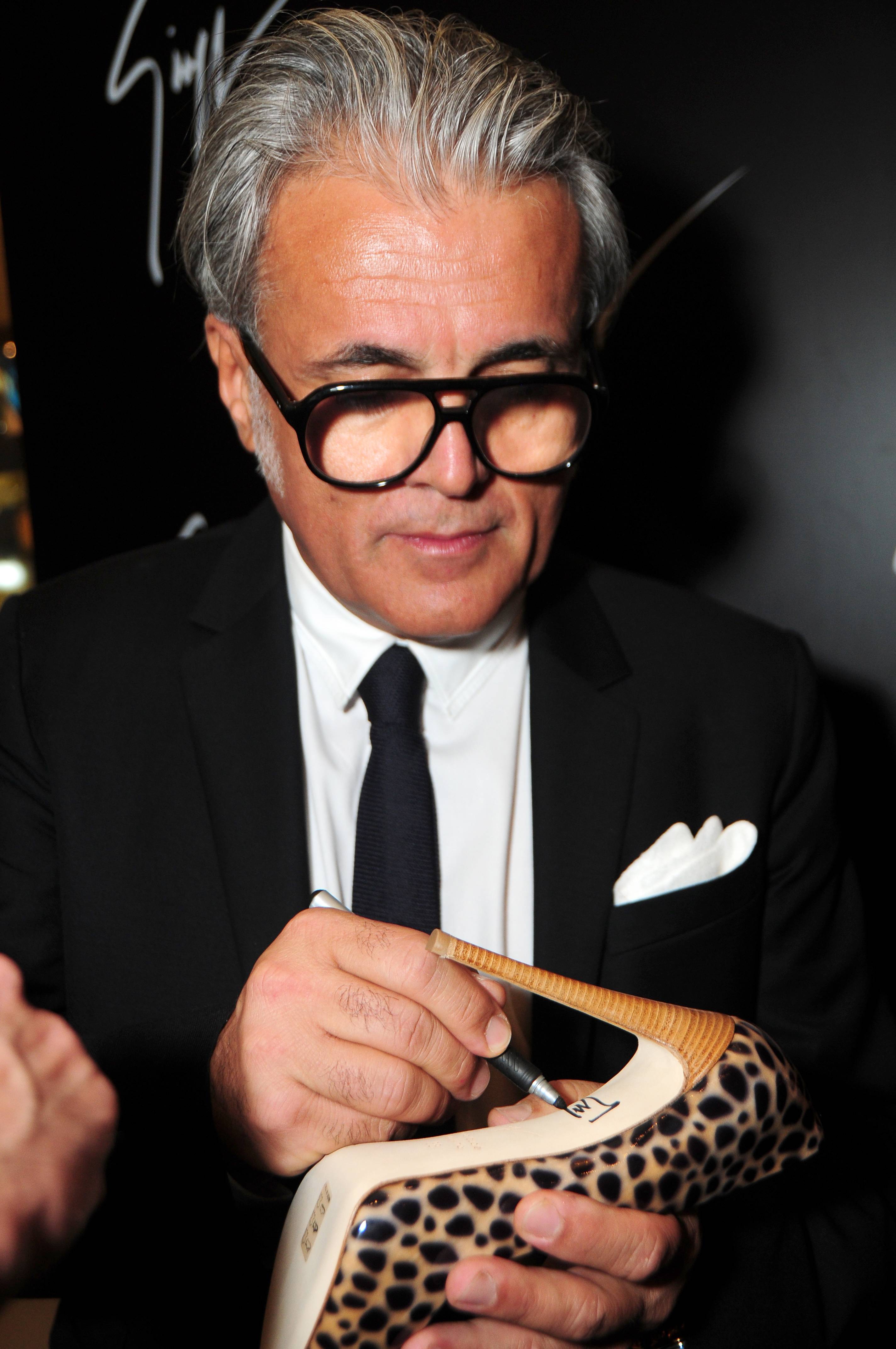 Giuseppe Zanotti signs a pair of his fabulous pumps.