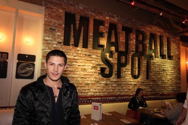 Alex Meraz poses in front of Meatball Spot sign.