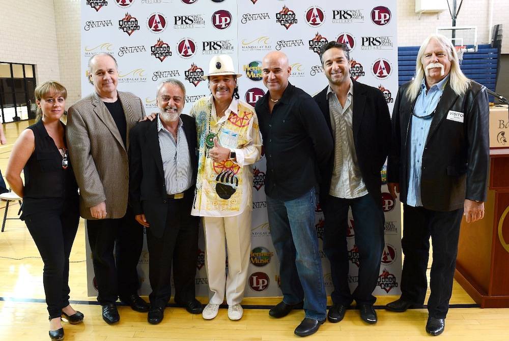 Recording artist Carlos Santana (L) and former tennis player Andre Agassi visit the Andre Agassi College Preparatory Academy to donate more than 200 guitars from Hermes Music and other instruments from LP Music and PRS Guitars for music students on September 10, 2013 in Las Vegas, Nevada. Santana returned to Las Vegas to continue his residency at the House of Blues Las Vegas.