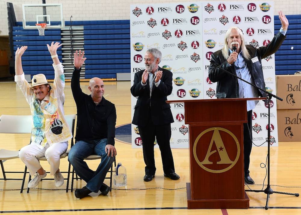 Recording artist Carlos Santana (L) and former tennis player Andre Agassi visit the Andre Agassi College Preparatory Academy to donate more than 200 guitars from Hermes Music and other instruments from LP Music and PRS Guitars for music students on September 10, 2013 in Las Vegas, Nevada. Santana returned to Las Vegas to continue his residency at the House of Blues Las Vegas.