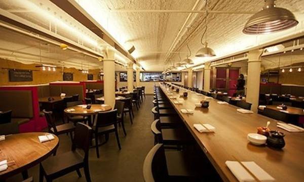 Huge communal table in Flesh & Buns, with booths on the side