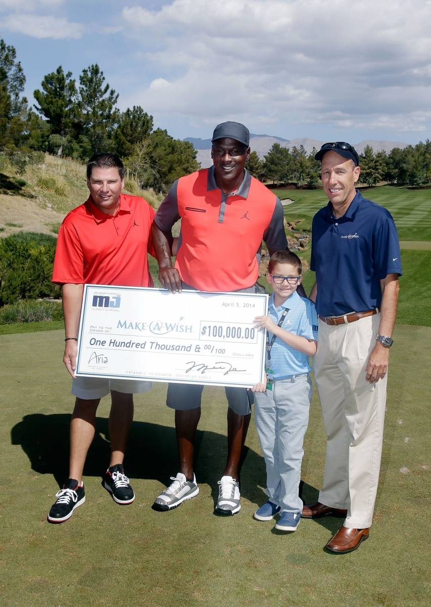 Executive Vice President MGM Resorts International Tyler Shook and NBA legend Michael Jordan present a check to Make-A-Wish Foundation