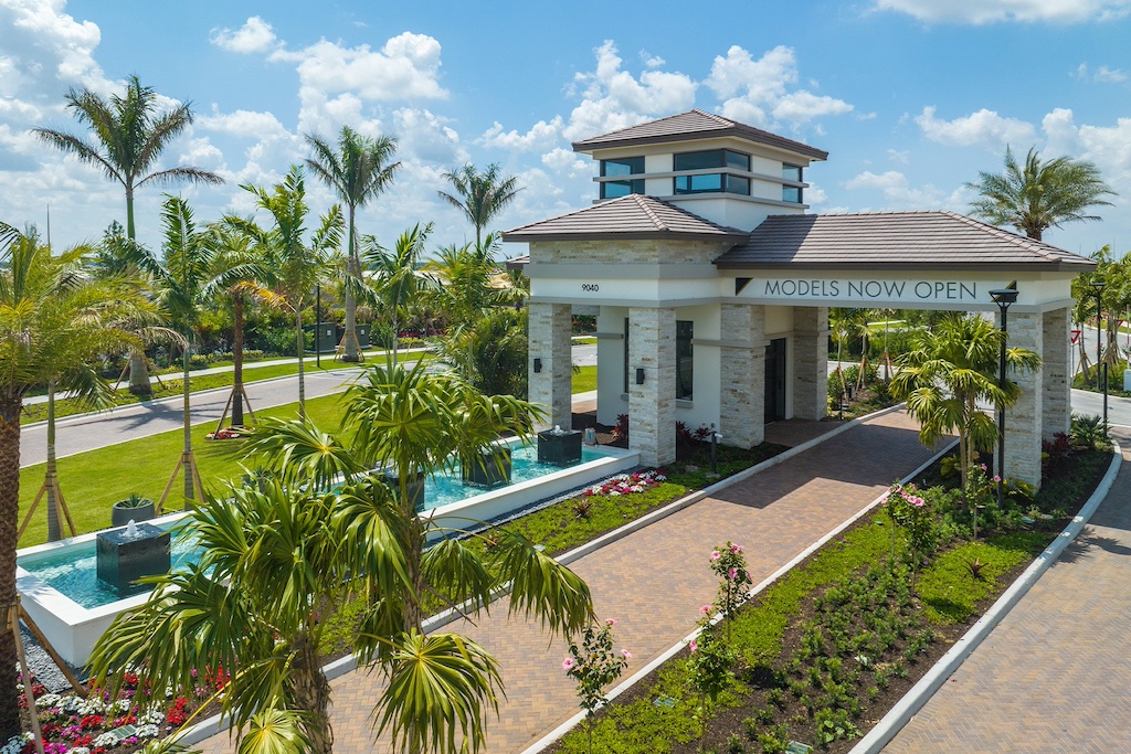 Elegant entrance to Valencia Grand showcasing modern architecture and lush landscaping, a luxury 55+ community by Itchko Ezratti's GL Homes in South Florida.