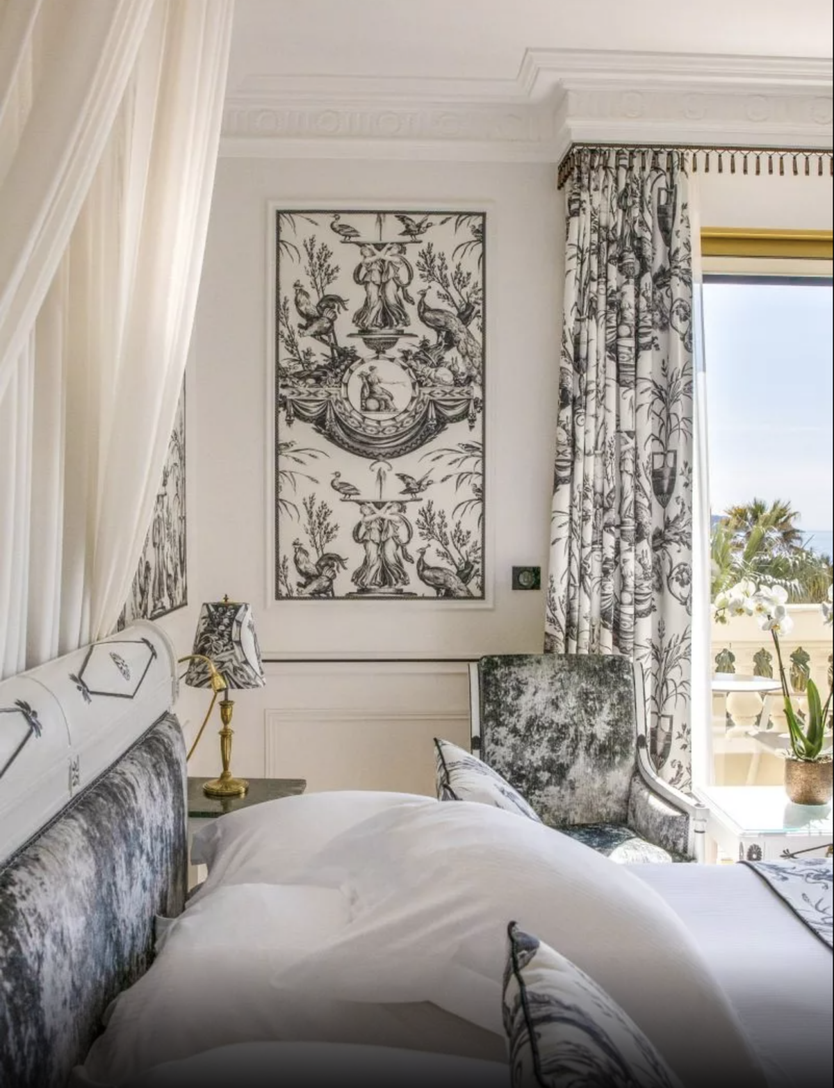 A decorated bedroom in a Le Negresco Signature Suite overlooking the sea