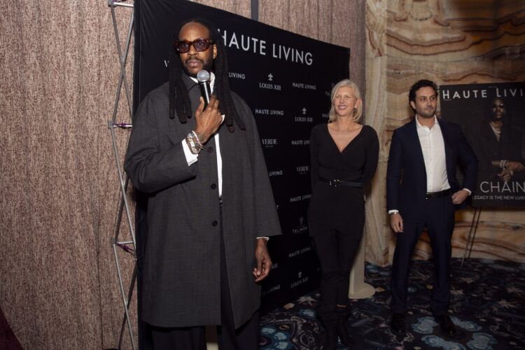 2 Chainz speaking at the Haute Living cover dinner beside April Irene Donelson and Clément Guenec