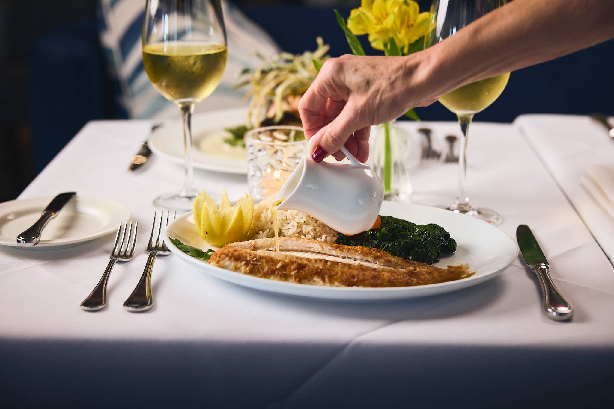 Sauce poured tableside over a fish entrée at Café L’Europe, a classic date night restaurant in Palm Beach