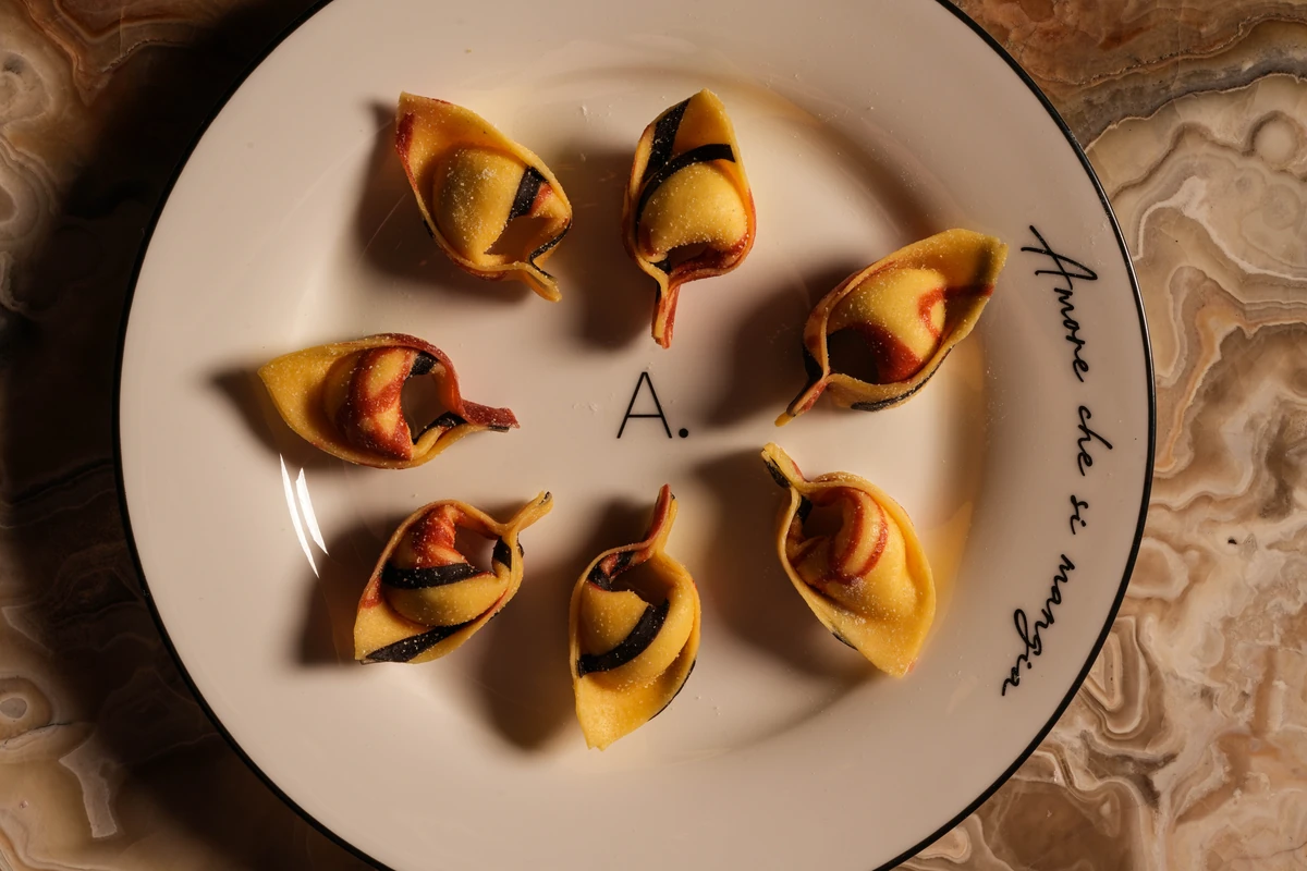 Overhead view of handmade filled pasta on a monogrammed plate at A Pasta Bar Miami Beach