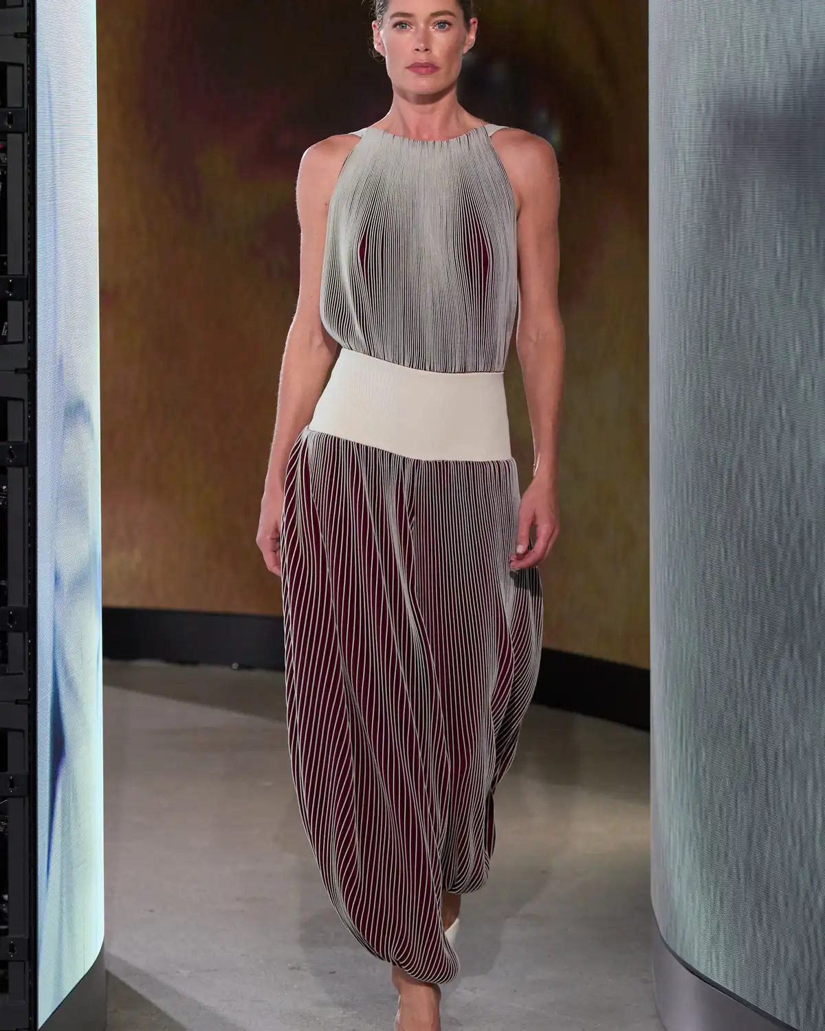 Doutzen Kroes in pleated silver and burgundy at the Alaïa Winter Spring 2027 show, Paris Fashion Week