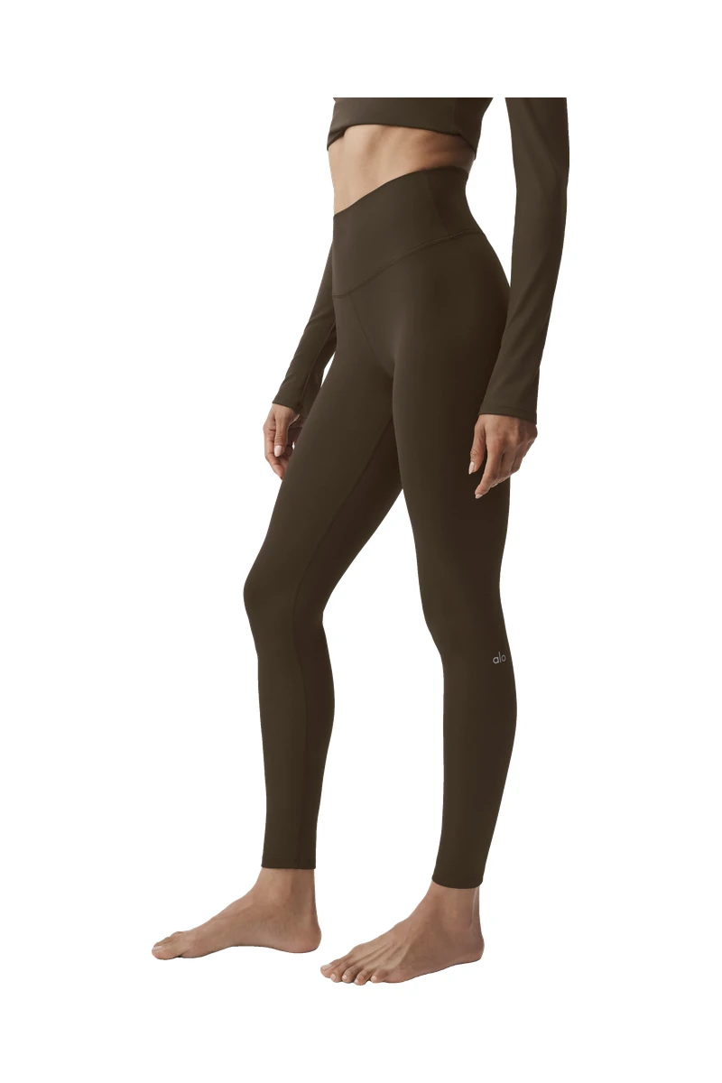 A model in the ALO Softsculpt High-Waist Legging in Espresso on a white background, a pick inspired by the ALO Plaza Athénée takeover