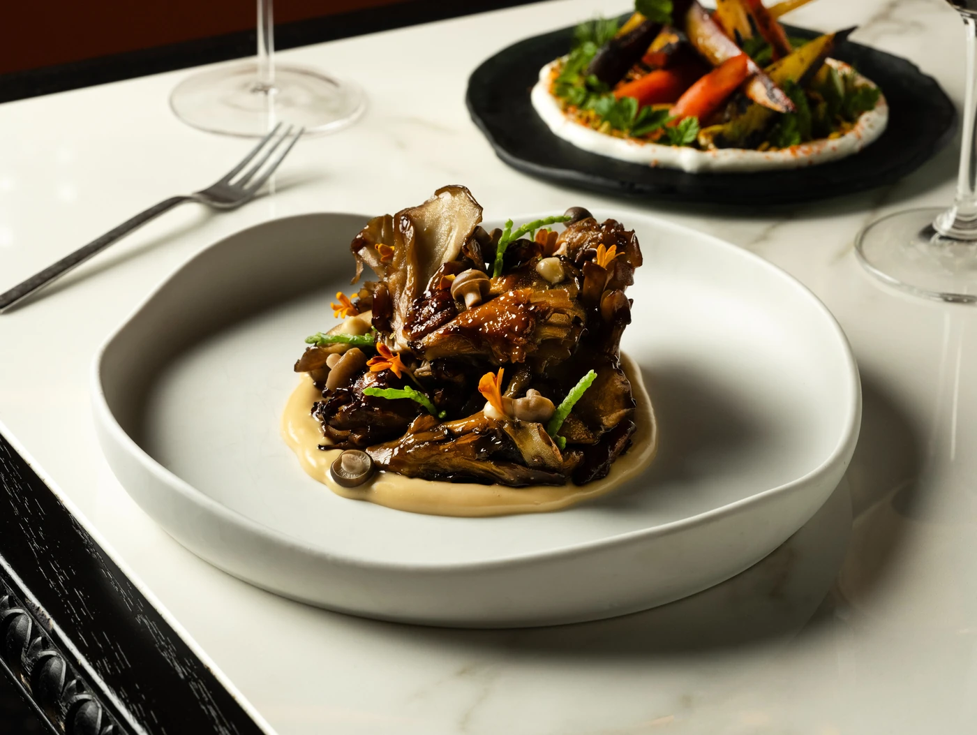 Roasted maitake mushrooms over a puree, garnished with edible flowers, at Bazaar Meat Miami Beach