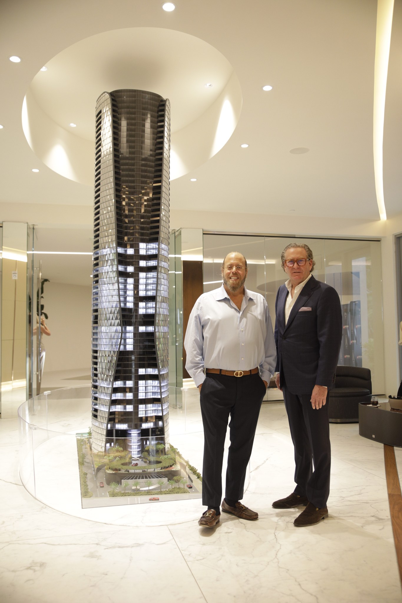 Two guests beside a model of the Bentley Residences Miami tower at the Torcal unveiling